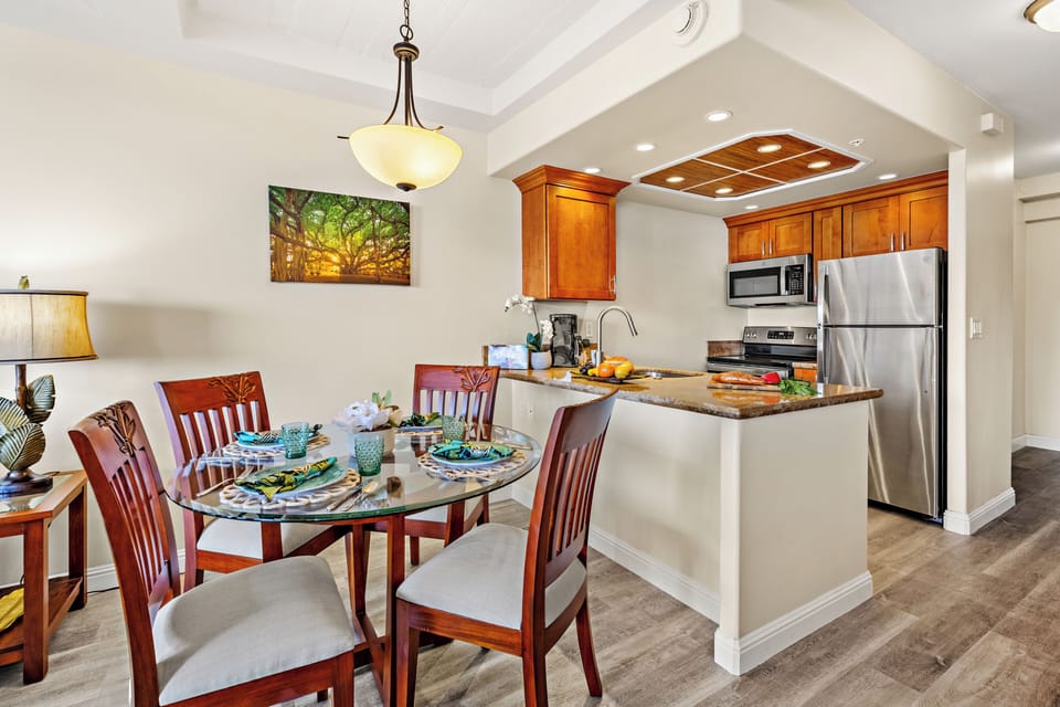 Bright and inviting open-concept kitchen featuring warm wood cabinetry, sleek granite countertops, and a spacious island that flows seamlessly into the living and dining areas. Perfect for entertaining or relaxing in comfort.