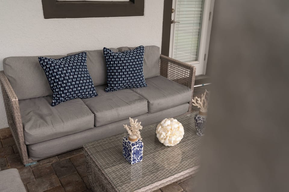 Relax in our stylish seating area featuring a plush gray sofa and chic glass coffee table. The natural light from the windows enhances this inviting space, perfect for enjoying warm conversations with friends and family.