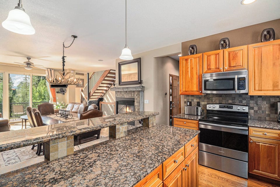 - Fully stocked kitchen with updated stainless appliances and wood cabinetry
- Granite countertops and pendant lights offer function and style in one
- Enjoy cooking with mountain views and easy access to dining and living areas

