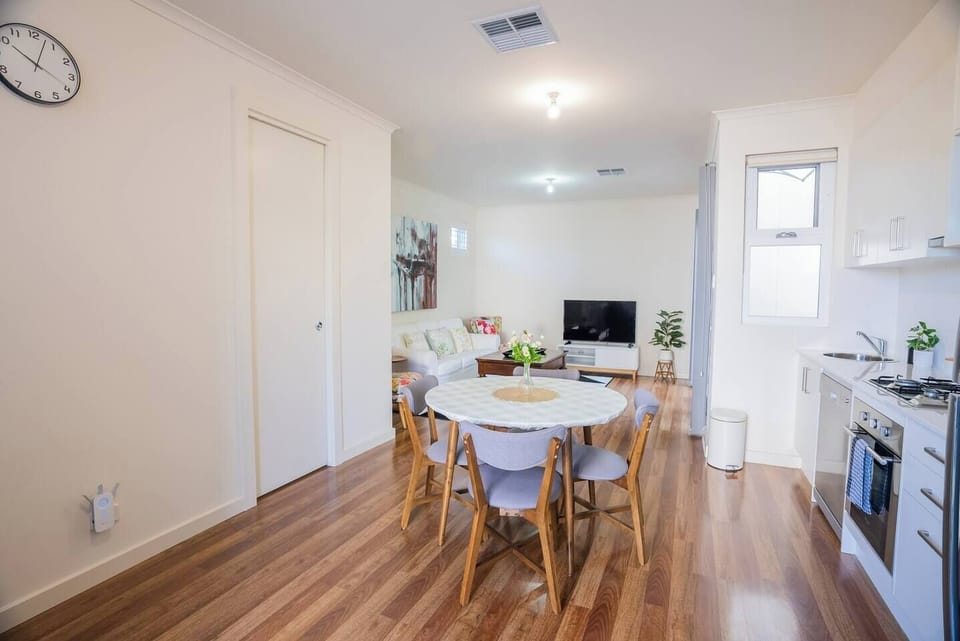 The living and kitchen is open plan with a dining table where guests can enjoy a meal at home.
