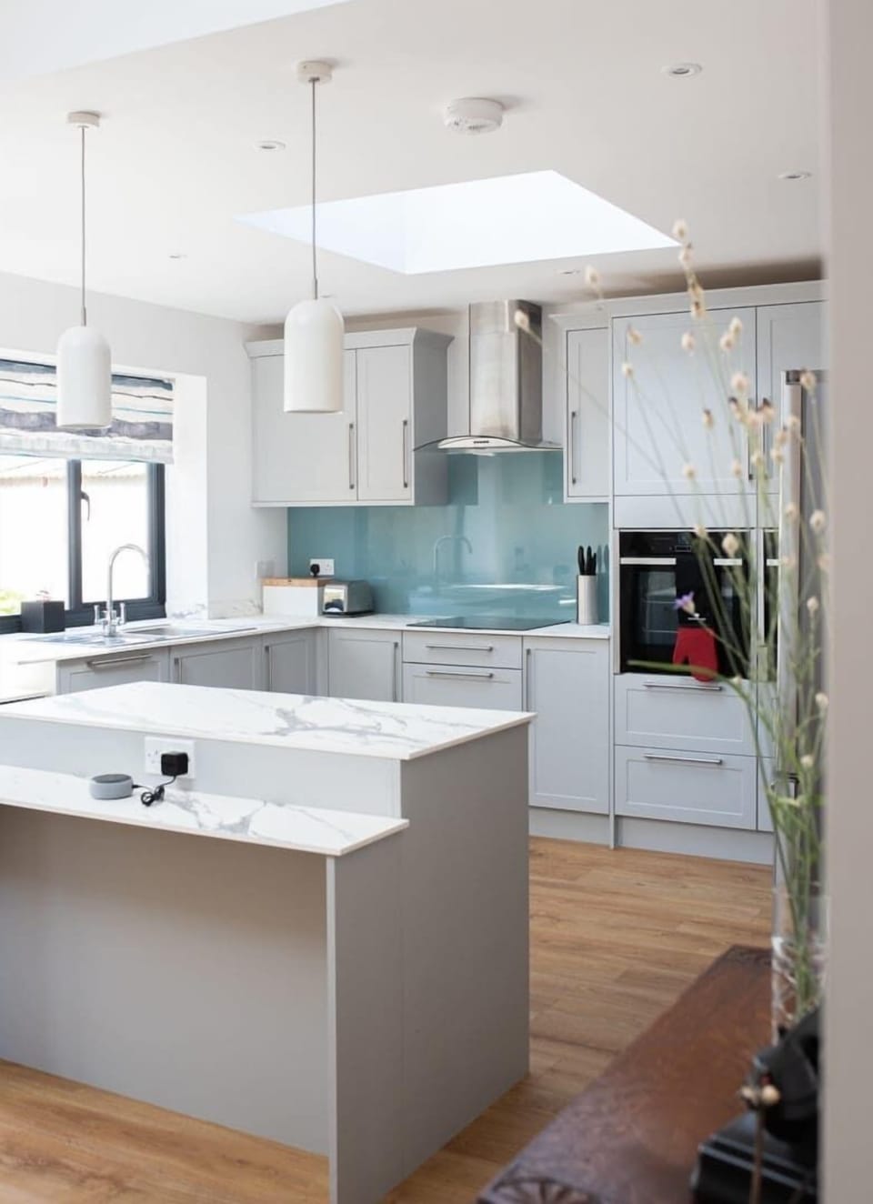 A clean and stylish kitchen featuring a spacious counter area, designed for both cooking and casual dining with modern appliances and ample workspace.