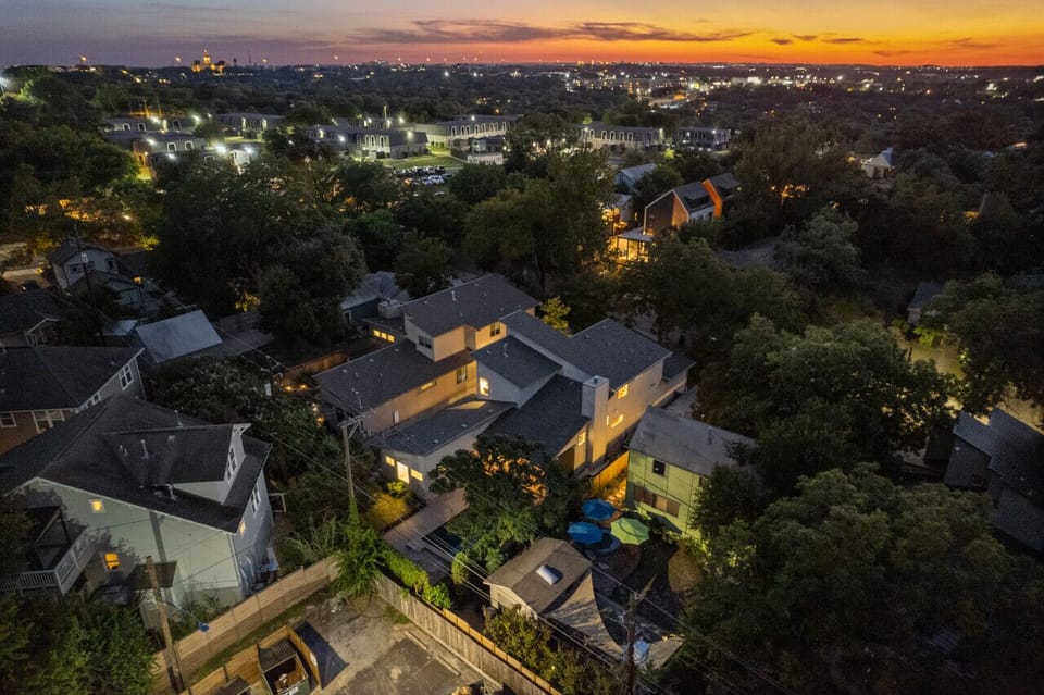From above, see the house surrounded by vibrant greenery, a serene retreat.