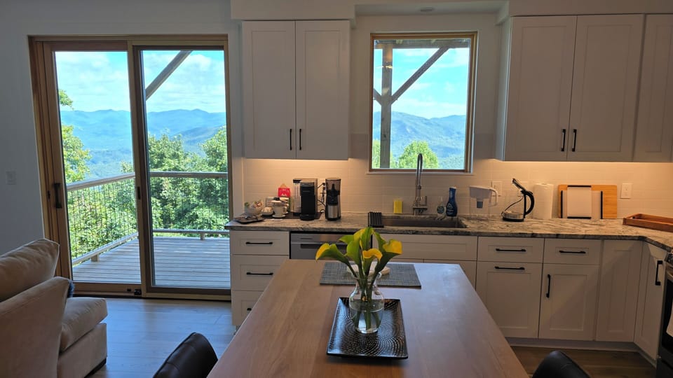 Raised dining table and fully stocked kitchen. Coffee bar stands ready.
