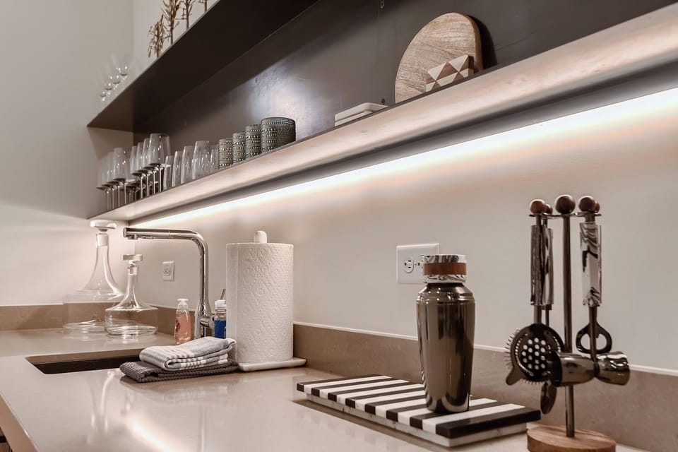 Unwind in our convenient hallway wet bar area, complete with a beverage fridge, sink, and glassware.