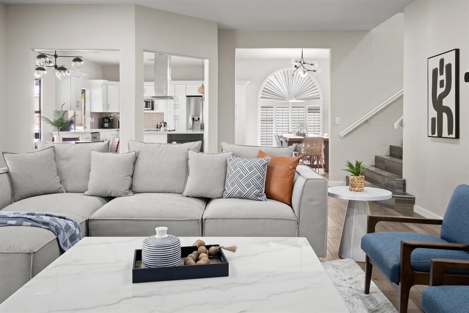 Featuring a grey plush sofa with the kitchen and dining area seamlessly connected at the back.