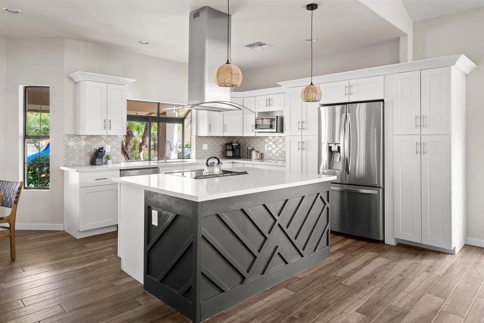 Featuring high-end stainless steel appliances, tons of white cabinetry, and a spacious island for all your culinary adventures