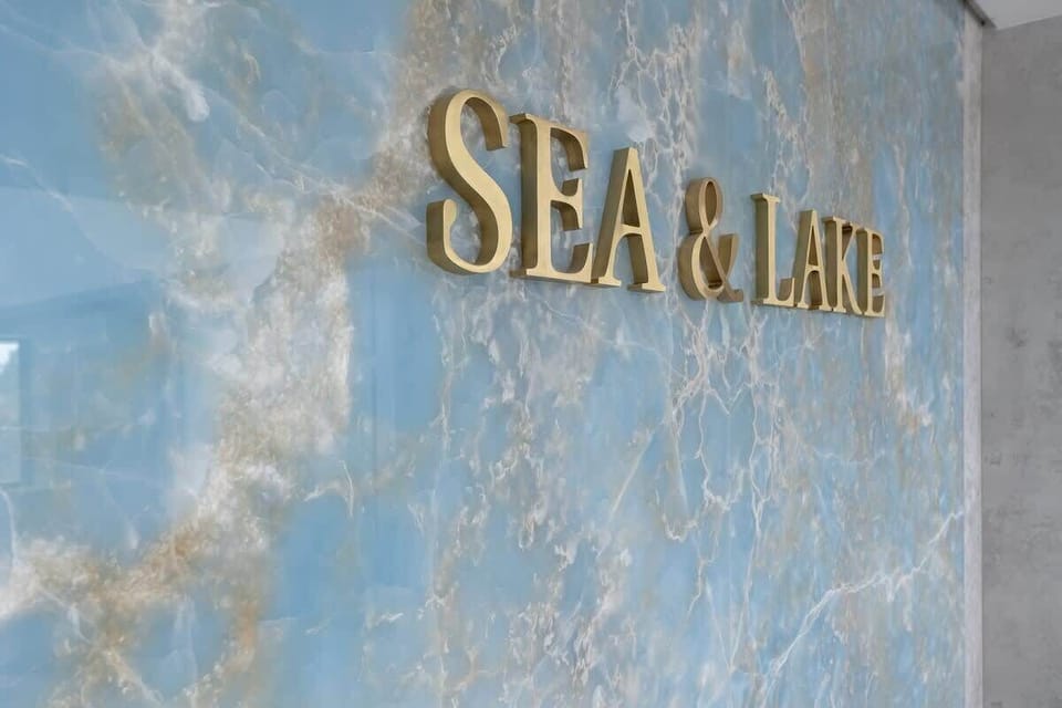 A close-up of the Sea & Lake sign on marble with golden letters. Reflects the luxury of the apartment complex.