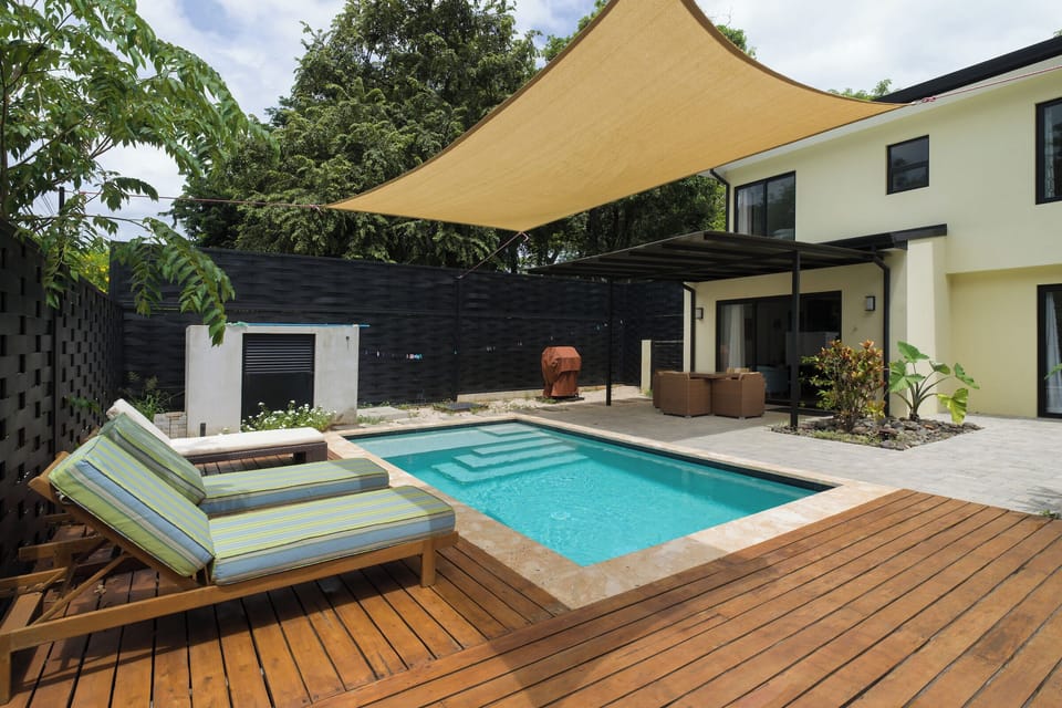 Ample outdoor spaces with sunshade over pool and covered patio