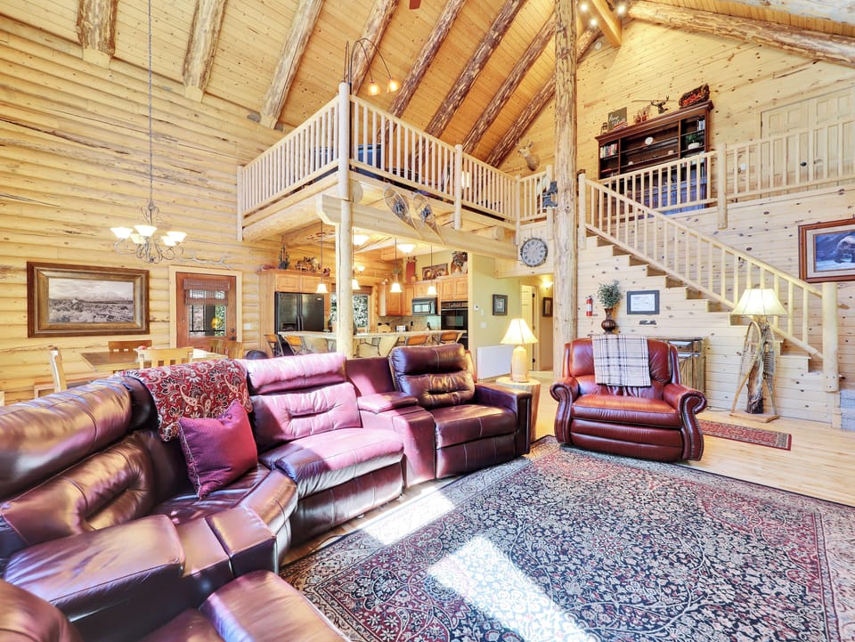 View of Living Room with ample seating and reclining chairs, gourmet kitchen and loft