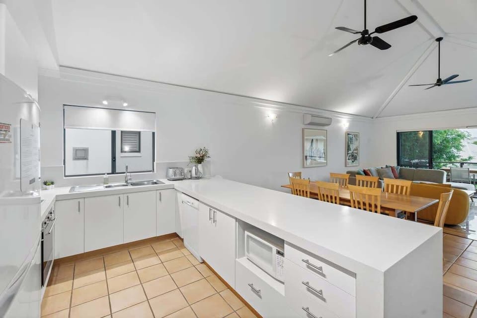 Spacious and fully equipped kitchen with modern appliances, a large island bench, and an open-plan layout leading to the dining and lounge area. Perfect for entertaining and family meals!