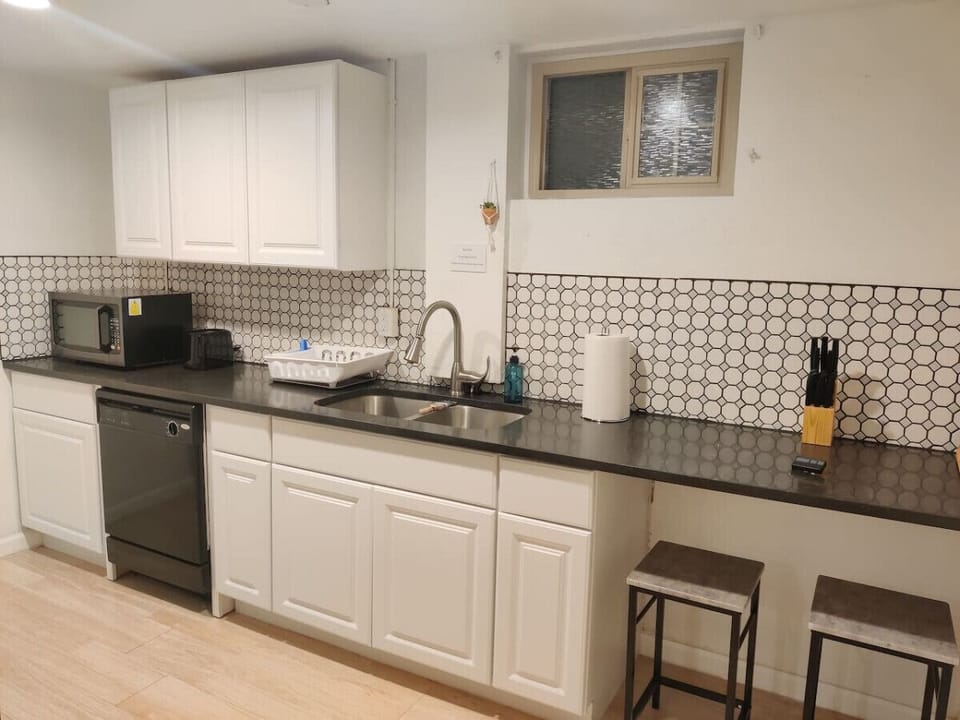 The small-sized kitchen has all new appliances. Refrigerator, microwave, dishwasher, stove, oven, toaster, and coffee maker. The kitchen is stocked with cooking basics such as pots, pans, bowls, plates, and cups.