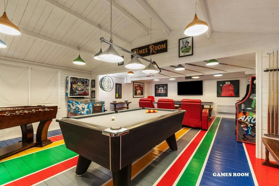 Games room with a pool table, table tennis, table football, dartboard, arcade games, seating area and TV
