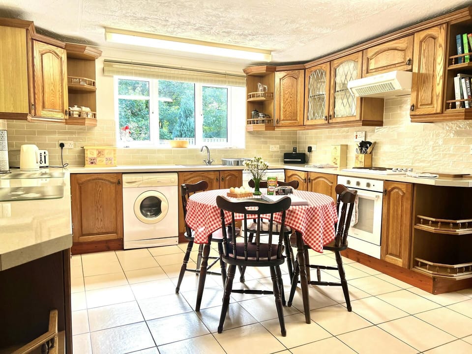 Kitchen with washing machine, cooker, kettle, toaster, dishwasher, dining table and four chairs