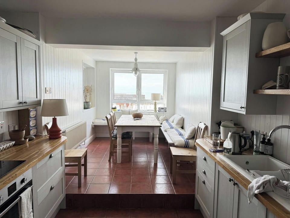Kitchen leading to the dining table with chairs and benches