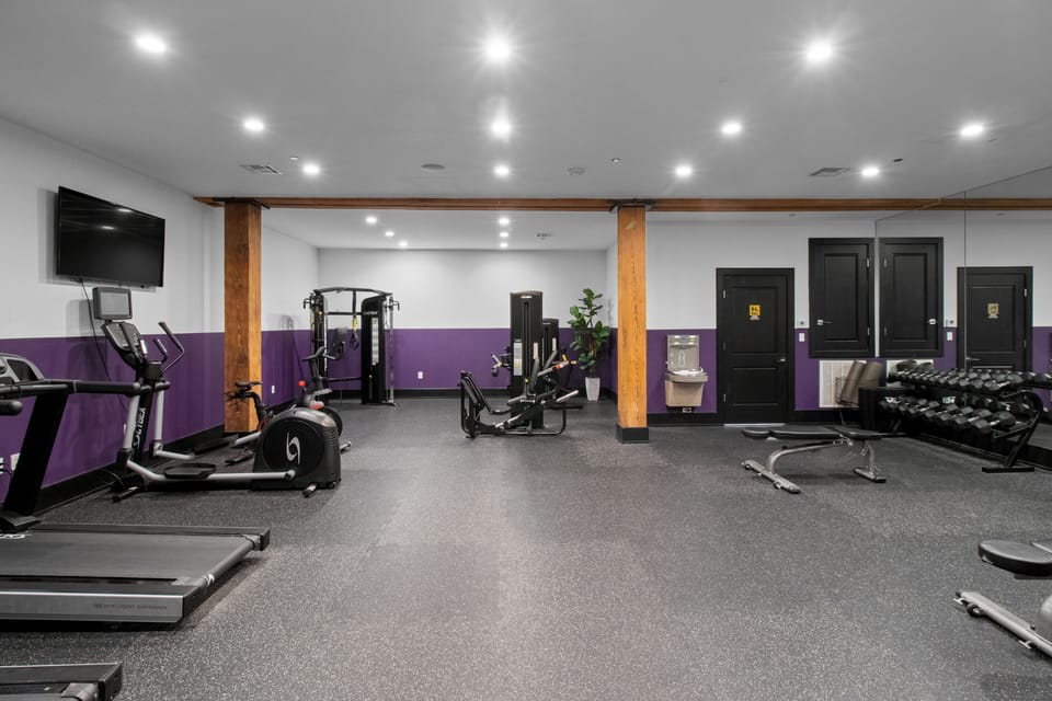 Stay fit at 888 Baronne's private hotel gym with Cybex strength machines, TRX bands, Peloton bike, cardio gear, free weights, smart TVs, and a filtered water station—all in a clean, modern space exclusive to guests in Downtown New Orleans.