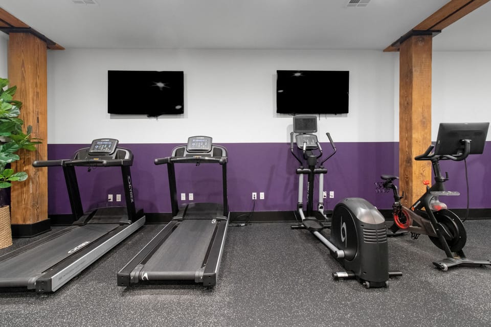 Stay fit at 888 Baronne Street with a fully equipped gym featuring Cybex machines, TRX bands, Peloton, cardio gear, free weights, smart TVs, and a filtered water station—all in a clean, modern space.