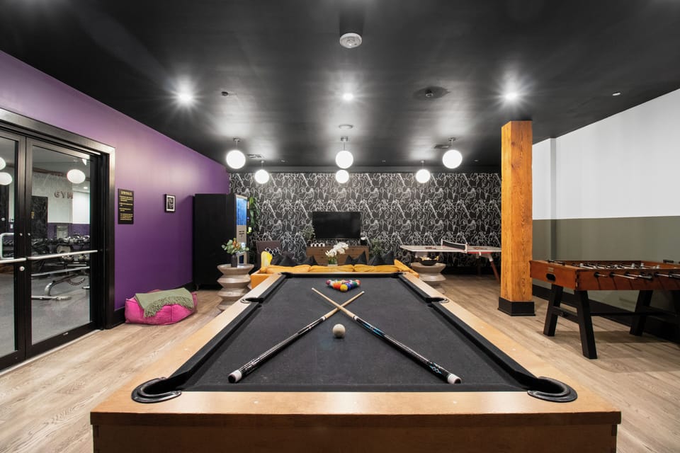 Enjoy friendly competition in 888 Baronne's guest-only game room with a pool table, ping pong, foosball, smart TV, and sofa lounge seating. Perfect for relaxing after a day in New Orleans—ideal for families, friends, and group getaways.