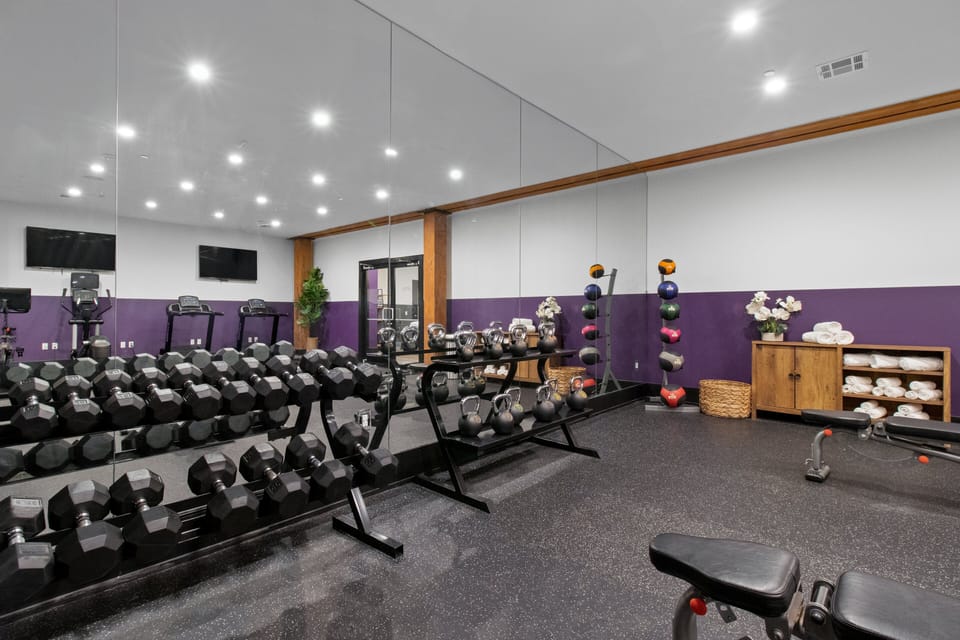 Stay fit at 888 Baronne Street with a fully equipped gym featuring Cybex machines, TRX bands, Peloton, cardio gear, free weights, smart TVs, and a filtered water station—all in a clean, modern space.