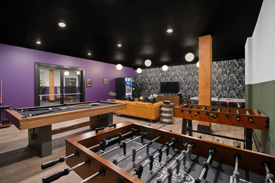 Enjoy friendly competition in 888 Baronne's guest-only game room with a pool table, ping pong, foosball, smart TV, and sofa lounge seating. Perfect for relaxing after a day in New Orleans—ideal for families, friends, and group getaways.