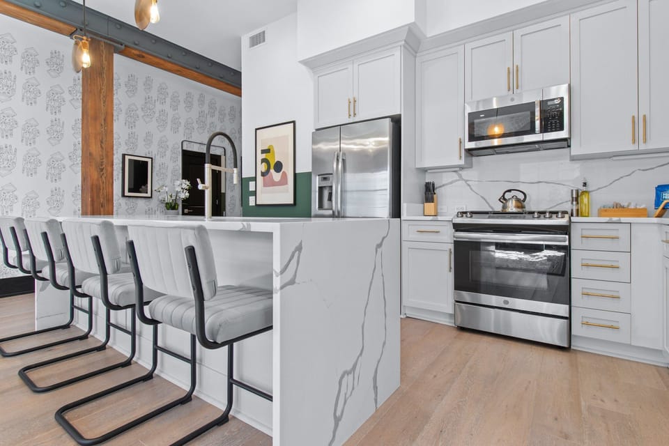Cook or snack in style with a full kitchen featuring GE stainless appliances, cookware, and an island with bar seating. Ideal for short or extended stays, our kitchens make group travel in New Orleans easy and comfortable.