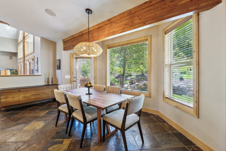 - Dining room with wood table seating for six guests  
- Large windows bring in natural light and garden views  
- Stylish lighting and tiled floors enhance mountain charm