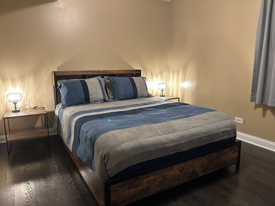 Master bedroom with 2 nightstands, lamps, a walk-in closet, and luggage rack