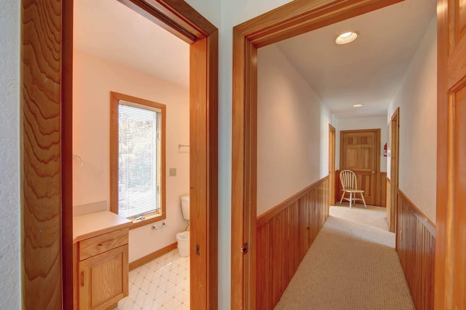 Convenient half-bath located just off the hallway with warm wood accents and plenty of natural light