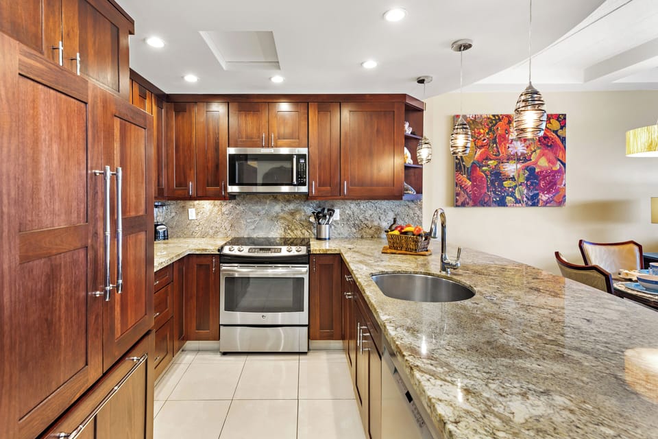 Beautifully designed kitchen featuring rich wood cabinetry, granite countertops, and stainless steel appliances—offering a polished and functional space with a clean, cohesive design.