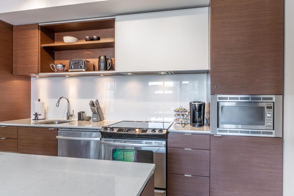 Cook with ease using the premium stainless steel gas range, integrated microwave, and ample modern counter space.