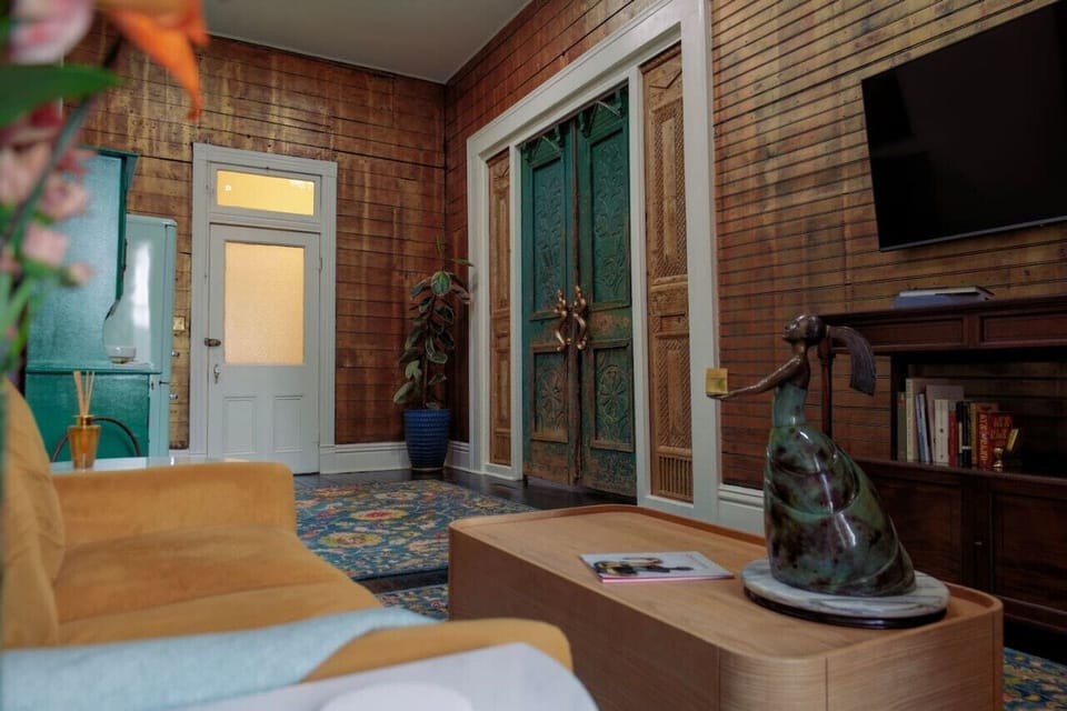 Living room, kitchenette, flat screen streaming tv, and those gorgeous nine foot doors that open up to the bedroom.