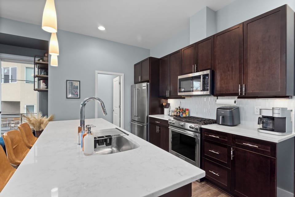 Fully equipped kitchen, quartz countertops, and stainless steel appliances.