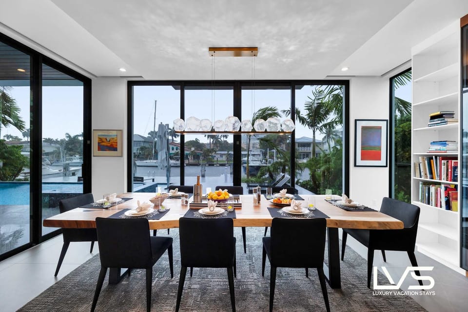 Dining Room-Anchored by a stunning, custom-designed table, the space is surrounded by sleek, upholstered chairs that promise a lavish dining experience.
