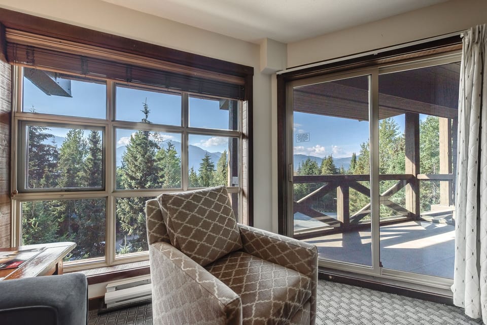 Relaxing seating area with beautiful outdoor views through large windows.