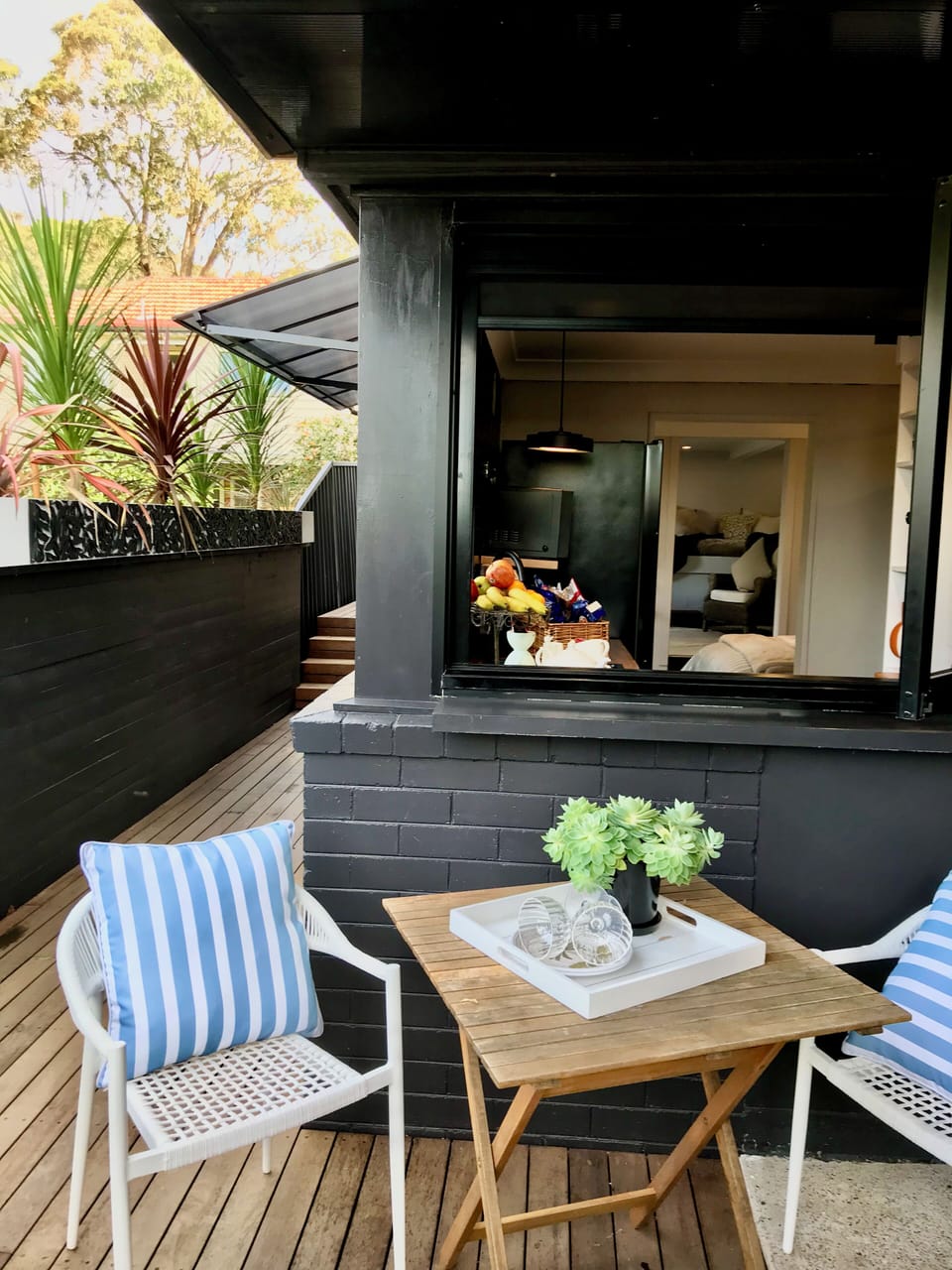 An outdoor breakfast area opens onto a deck through a bi-fold window.