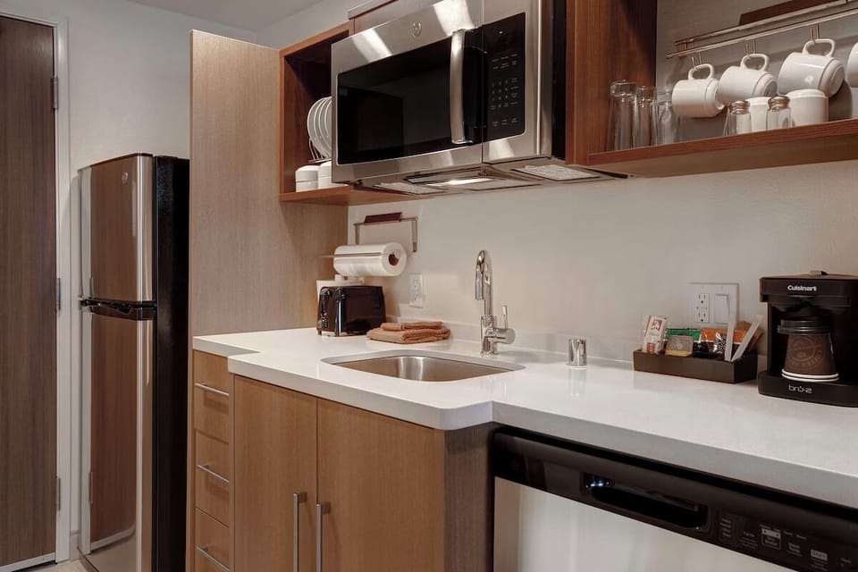 Prepare easy snacks with fridge, microwave, sink, and coffee setup.