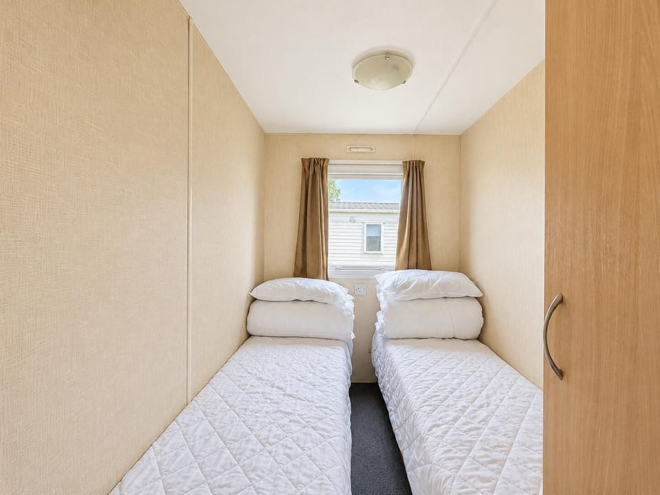 The twin beds are arranged to maximise space and comfort in the room of the static caravan.