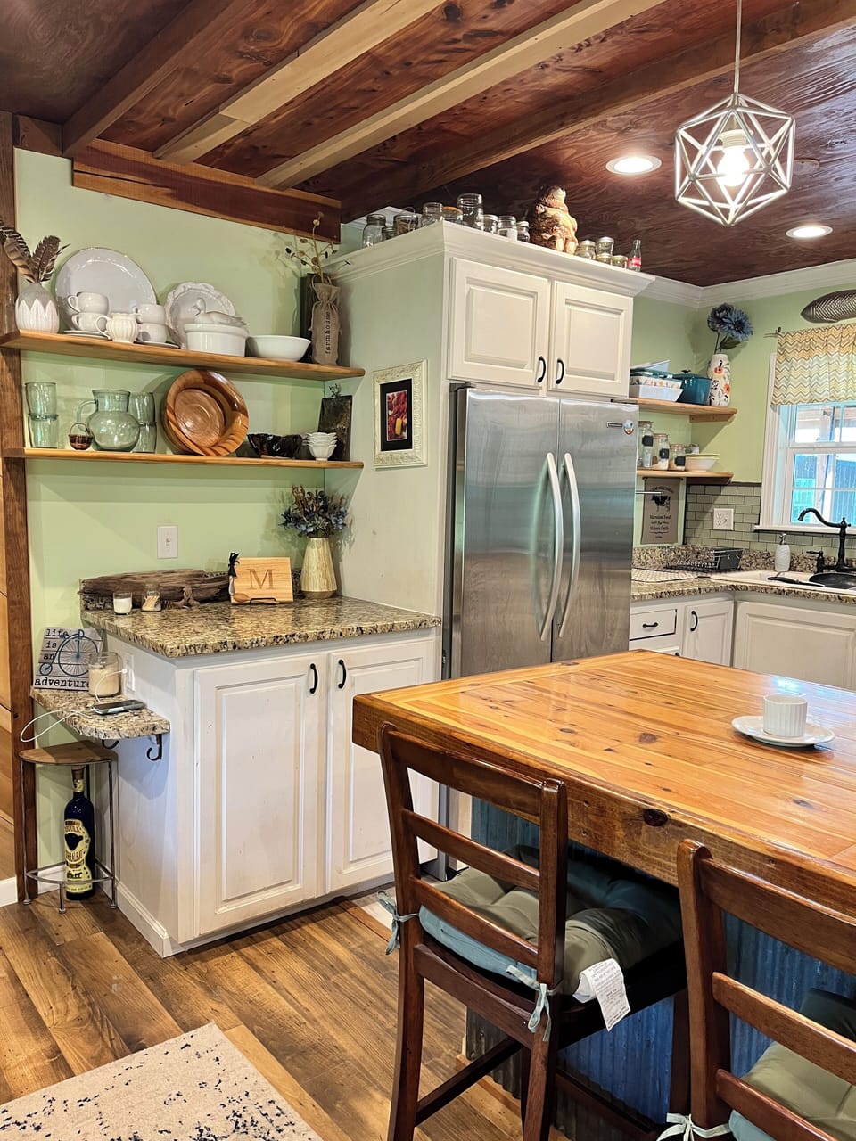 Full kitchen with refrigerator, freezer, and large island bar for seating.