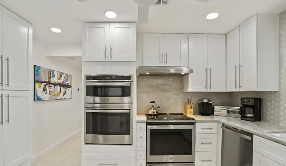 Kitchen with quartzite counters, high end appliances, and cooking utensils.