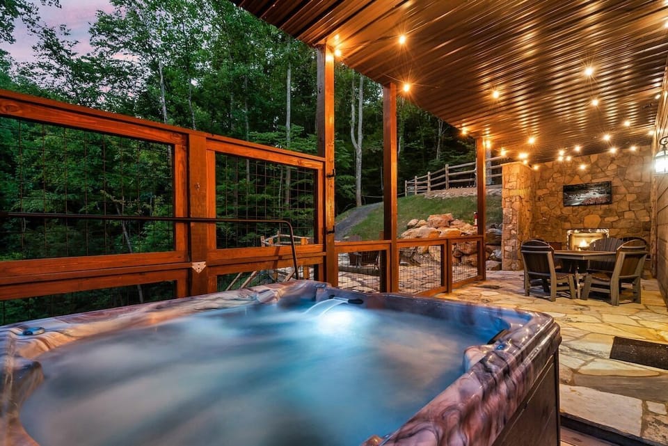 Ease into the hot tub while the fire is ablaze in the stone outdoor fireplace a few steps away, string lights overhead, dinner table close by, nowhere else you need to be.