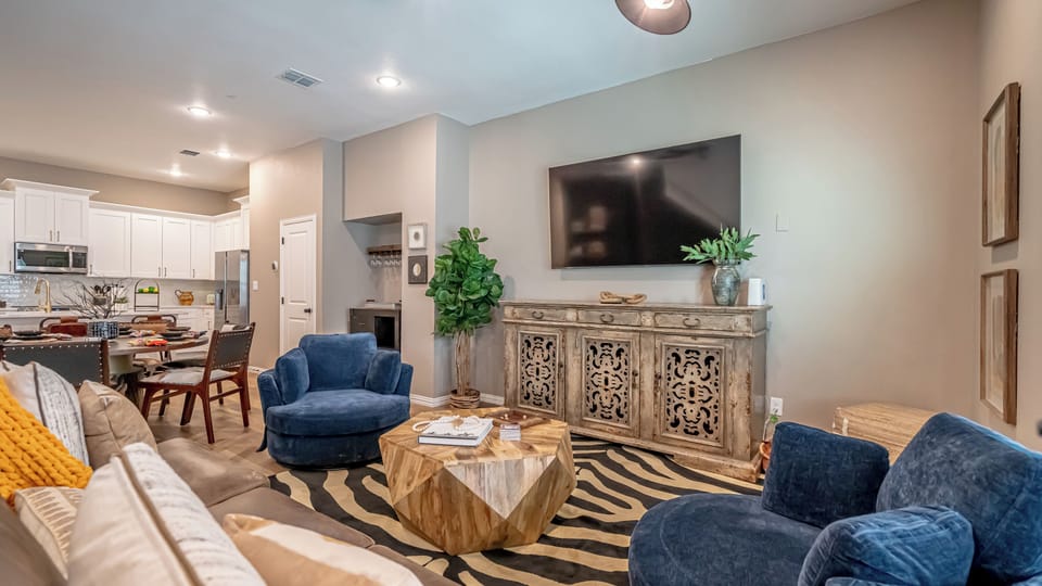 The living room is a stylish, comfortable space with a large TV and plush seating, perfect for unwinding or gathering with friends and family.