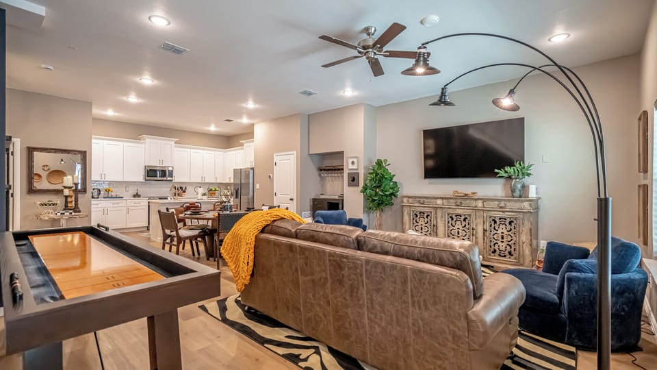 The living room is a stylish, comfortable space with a large TV and plush seating, perfect for unwinding or gathering with friends and family.
