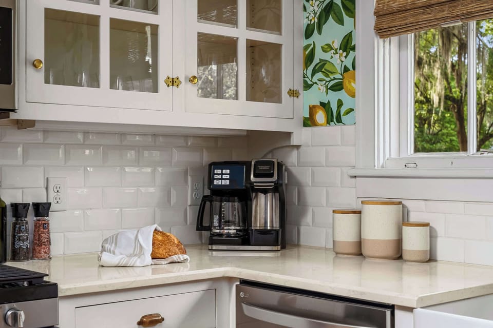Kitchen equipped with a coffee maker and cabinets for ample storage.