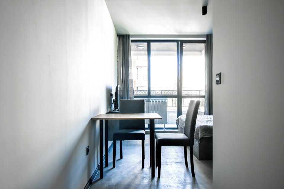 “Enter the heart of our studio, where modern industrial aesthetics blend seamlessly with comfort. Concrete walls and warm wooden accents create a welcoming space perfect for both relaxation and work.”
