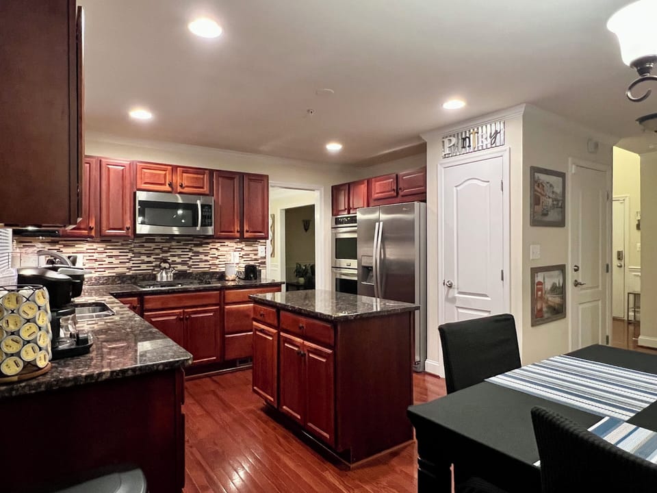 The kitchen features granite countertops, an island, and an area to dine in.