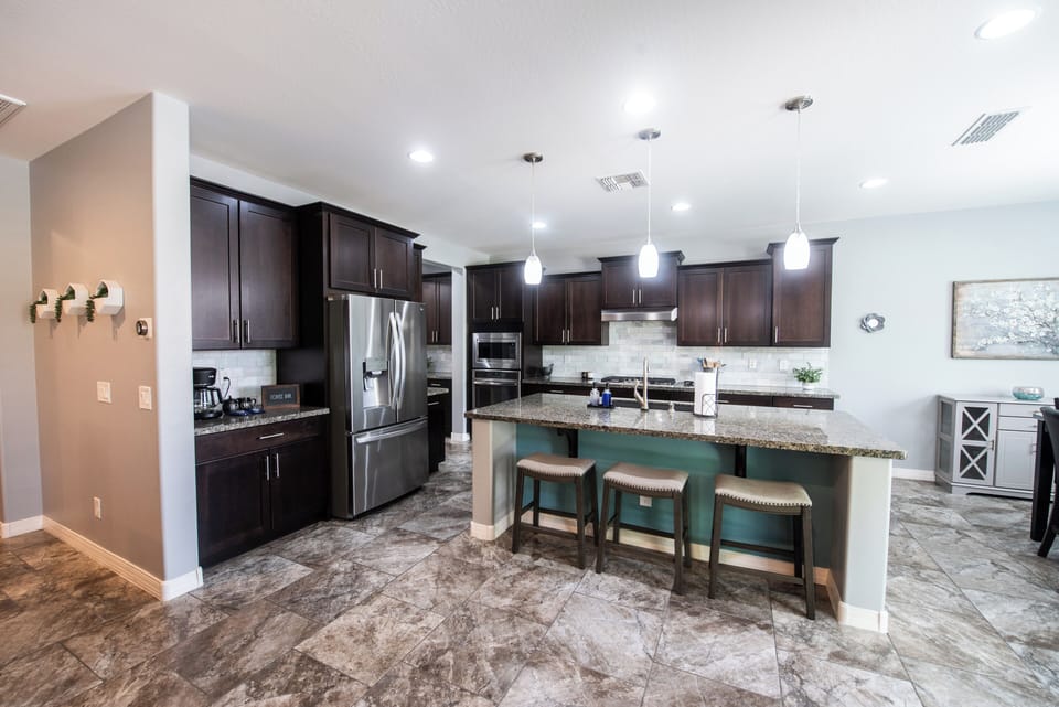 Kitchen island with seating for three and pendant lights.