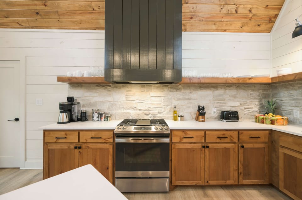Stylish kitchen with wooden cabinets, stainless steel stove, and fruit accents.