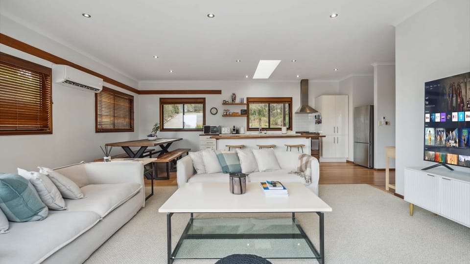 Bright open-plan room combining the main lounge, dining table, and kitchen.