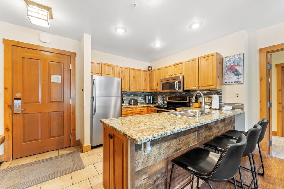 Your fully equipped kitchen welcomes you with warm wood cabinetry and granite countertops, perfect for preparing meals together.