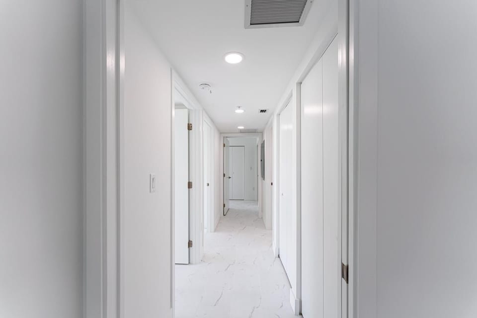 Three bedrooms along their own hallway, each with a door that closes.