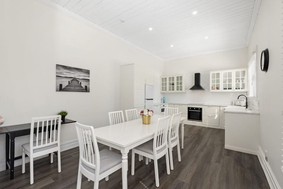 Open-plan dining with a 6-seater modern dining table and kitchen area.